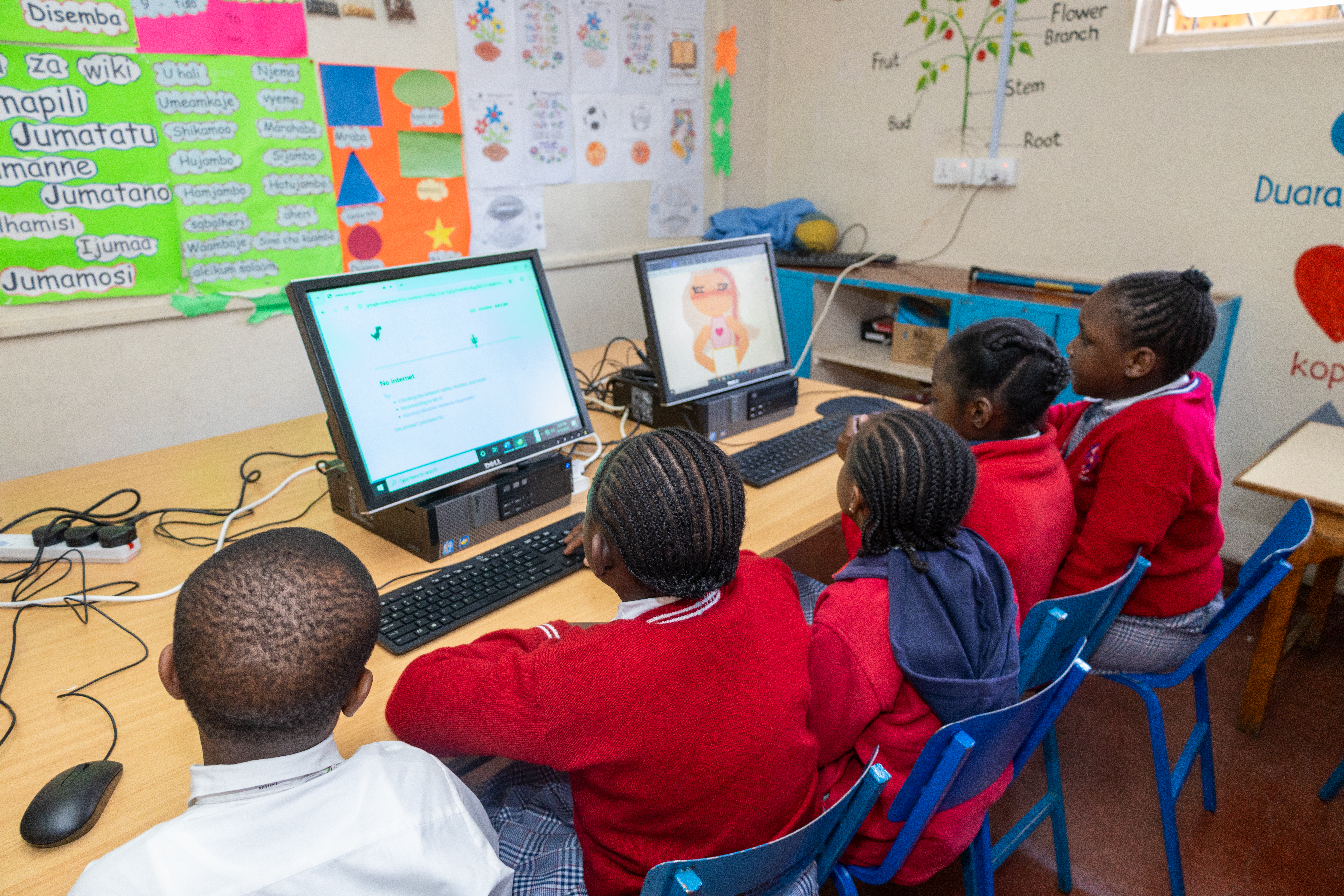 Children in uniform learning on computers in a classroom