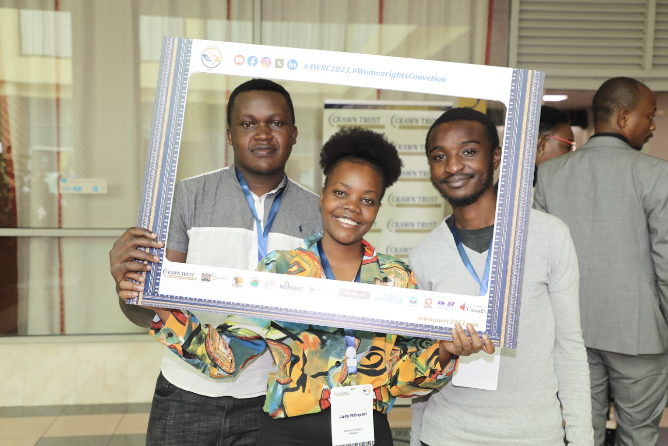Three attendees posing with a branded photo frame at the AWRC2023 convention