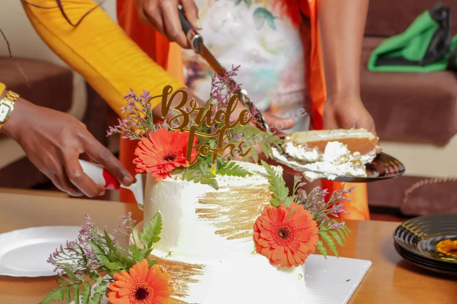 Close-up of a beautiful celebration cake with flowers being cut